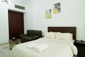 a bedroom with a large bed with two towels on it at Cozy Private Studio -Near Beach -City View -Downtown Sharjah - Pool & Gym in Sharjah