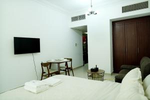a bedroom with a bed and a living room with a table at Cozy Private Studio -Near Beach -City View -Downtown Sharjah - Pool & Gym in Sharjah +30 photos