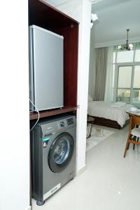 a living room with a washing machine and a tv at Cozy Private Studio -Near Beach -City View -Downtown Sharjah - Pool & Gym in Sharjah