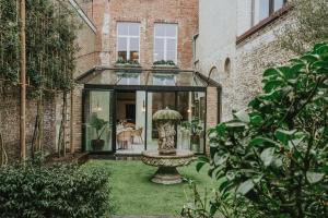 a glass house with a fountain in the yard at The Burgundy - Boutique B&B in Bruges