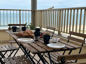 a wooden table with a plate of food on a balcony at Le Terrazze Beachfront, balcony, parking, private access Beach in Torvaianica