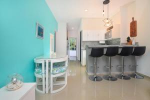 a kitchen with a table and stools in a room at Pool, Near Marinas, Reefs, Family Fun, 2BR Condo, Main Level in Cozumel +65 photos