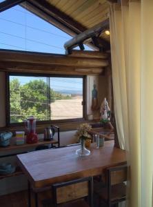 une salle à manger avec une table et une grande fenêtre dans l'établissement Bella Vista, à Imbituba