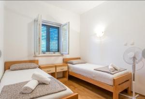 zwei Betten in einem Zimmer mit Fenster in der Unterkunft HOLIDAY HOUSE Ose in Mirce