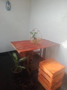 a wooden table with a potted plant and a bench at Riyon Rooms and Restaurant in Weligama
