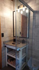 a bathroom with a sink and a mirror at Cabañas Altos del Bosque in Mar del Plata