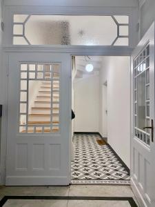 einen Flur mit einer weißen Tür und einer Treppe in der Unterkunft Freytag im Uni-Viertel in Duisburg