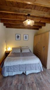 a bedroom with a large bed and a wooden ceiling at Cabañas Altos del Bosque in Mar del Plata
