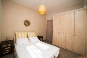 a bedroom with a white bed and a large closet at Prokymaia Penthouse Apartment in Rethymno