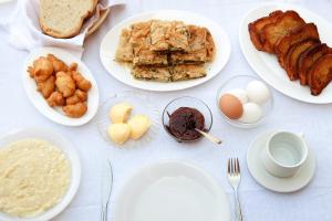 einen Tisch mit Teller mit Speisen, Eiern und Brot in der Unterkunft To Petrino Guesthouse in Agios Germanos