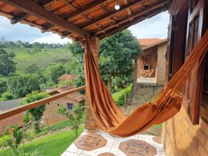 a hammock on the balcony of a house at Pousada Canto da Serra in Conceição da Ibitipoca