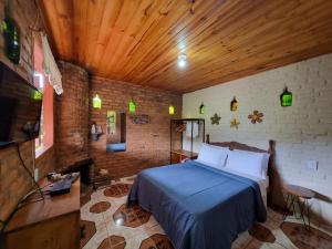 a bedroom with a bed in a room with a wooden ceiling at Pousada Canto da Serra in Conceição da Ibitipoca