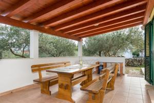 ein Holztisch und Bänke auf einer Terrasse in der Unterkunft HOLIDAY HOUSE Ose in Mirce