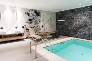 a bathroom with a pool and a table and chairs at SULO VIP Spa in Atyrau