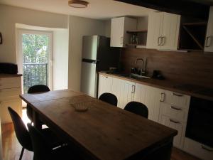 eine Küche mit Tisch und Stühlen und einem Kühlschrank in der Unterkunft Appartement tout confort 7 personnes à Porté-Puymorens in Porté-Puymorens