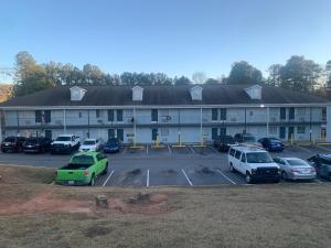 Un gran edificio con coches aparcados en un estacionamiento. en Live In Lodge Lilburn, en Snellville