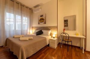 um quarto com uma cama, uma secretária e uma janela em MAGICFIVEROOMS di ANISA em Roma