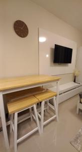 a desk with a clock and a tv on a wall at Condo in Lapu-Lapu City in Suba