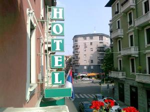 un panneau indiquant un hôtel situé sur le côté d'un bâtiment dans l'établissement Hotel Losanna, à Milan