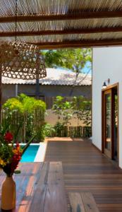 a wooden deck with a table and a vase of flowers at Bahia Soul - Vilas de Maré - Taipu de Fora - Península de Maraú in Marau +74 photos