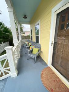 a porch with chairs and a table on a house at Vacation house in Galveston
