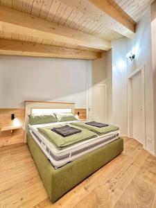 a large bed in a room with a wooden ceiling at Cá de Lares in Peio