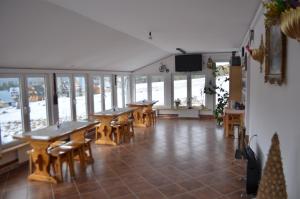 Zimmer mit Tischen, Stühlen und Fenstern in der Unterkunft Willa Czerwone Wierchy in Kościelisko