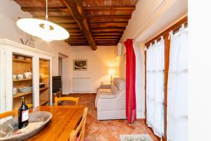 a living room with a table and a couch at Podere Vergianoni con piscina e vista mozzafiato in Tavarnelle in Val di Pesa
