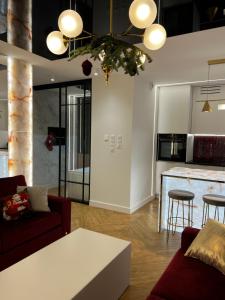 un salon avec un canapé et une cuisine dans l'établissement Apartament Primavera 4 Premium MINI SPA Dwa bliźniacze Apartamenty, à Kielce