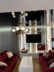 - un salon avec deux canapés rouges et une télévision dans l'établissement Apartament Primavera 4 Premium MINI SPA Dwa bliźniacze Apartamenty, à Kielce