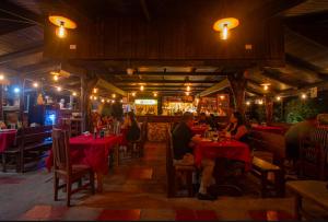a group of people sitting at tables in a restaurant at Cabinas La Fulanita in Nicoya