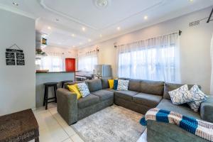 a living room with a couch and a kitchen at KhayaLethu Vic Falls in Victoria Falls