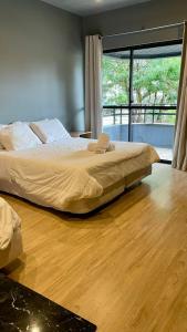 a bedroom with a large bed and a wooden floor at Mighil Hotel in Florianópolis