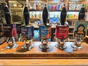 a group of four bottles of beer on a bar at The Eelsfoot inn in Theberton
