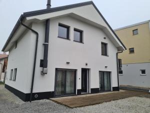 ein weißes Haus mit schwarzen Fenstern auf einer Straße in der Unterkunft Maya-K apartment near city center in Ljubljana