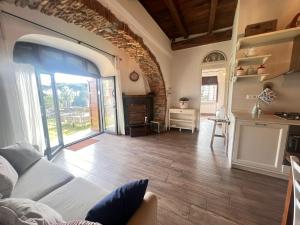 a living room with a white couch and an open door at La Torre Guest House in Anguillara Sabazia