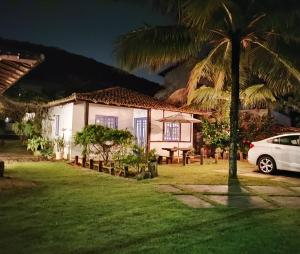 a white car parked in front of a house at Casinhas do Peró Refúgio com Jardim e WiFi Rápido in Cabo Frio