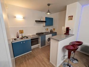 a small kitchen with blue cabinets and a sink at Appart Borderouge city in Toulouse