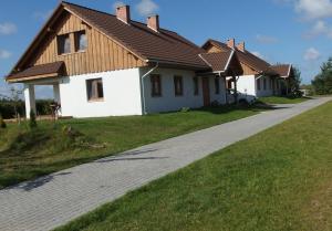 a white house with a brown roof at Zielony-Bursztyn in Objazda-Kolonia