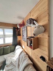 a bedroom with a bed and a wall with wood at Terrasse, vue imprenable et accès direct pleine nature, votre refuge idéal in Orcières