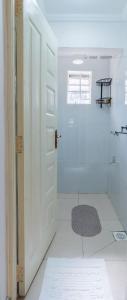 a bathroom with a shower and a white door at Perfect 2BR Airport Layover Transit Accommodation - High Speed WiFi 30mbps in Nairobi +15 photos