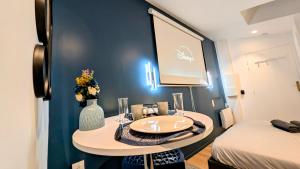 a small room with a table and a projection screen at Le Rêve Bleu 1er Étage in Abbeville