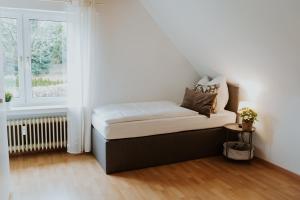 a small bed in a room with a window at Moderne Wohnung in Siershahn - Westerwald in Siershahn