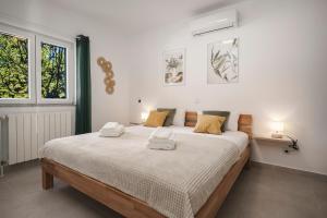 een slaapkamer met een groot bed met twee handdoeken erop bij Villa Mia - Moderne Oase mit Meerblick und Pool in Vodice +113 foto's