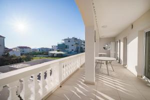 een balkon met een tafel en uitzicht op de stad bij Villa Mia - Moderne Oase mit Meerblick und Pool in Vodice