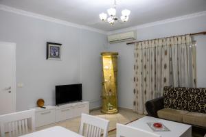 a living room with a couch and a tv at Ozzy apartment in Shkodër