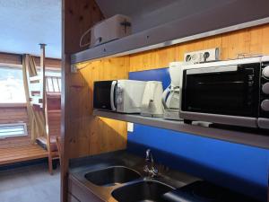 a kitchen with a sink and a microwave on a shelf at Résidence Cascade - Studio 2 personnes à Arc 1600 ski aux pieds et proche des commerces MAE-2156 in Arc 1600