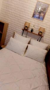 a bed with white sheets and pillows in a room at Studio The Cozy Corner in Timişoara