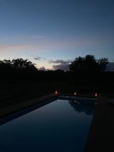 a swimming pool at night with lights in the water at Château Batsères in Landiras