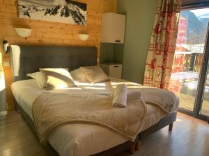 a large bed in a room with a window at Hotel Le Concorde in Morzine